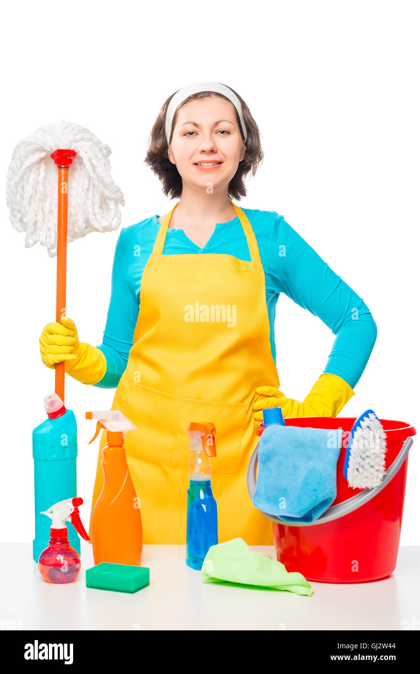 Portrait of a housewife with a mop and cleaning agents on the table