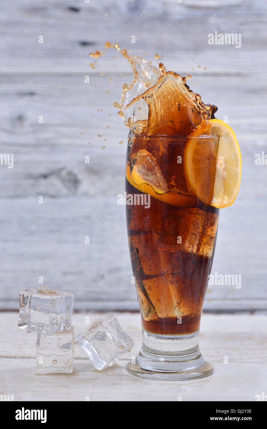 Lemon slice splashes in a glass full of cola and ice cubes Stock Photo ...