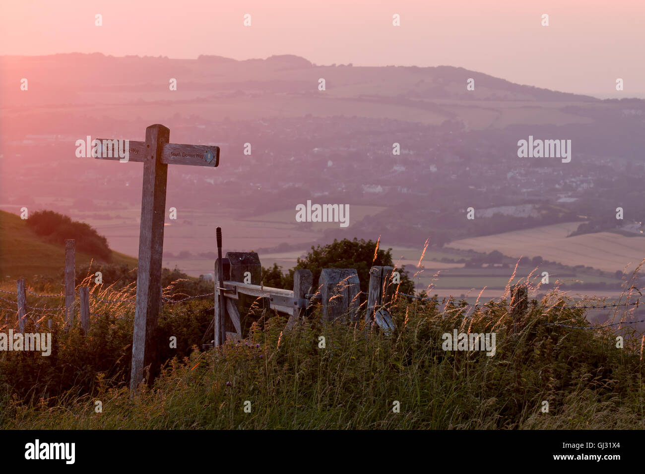 View from South Downs Way marker post near Firle Beacon at sunset. Stock Photo