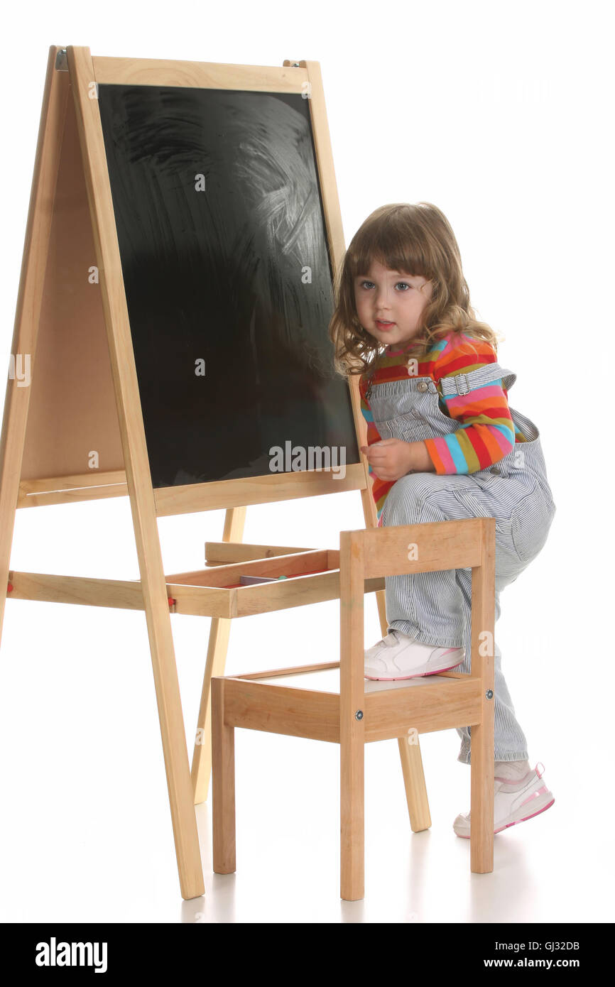 little girl climbing on a chair Stock Photo Alamy