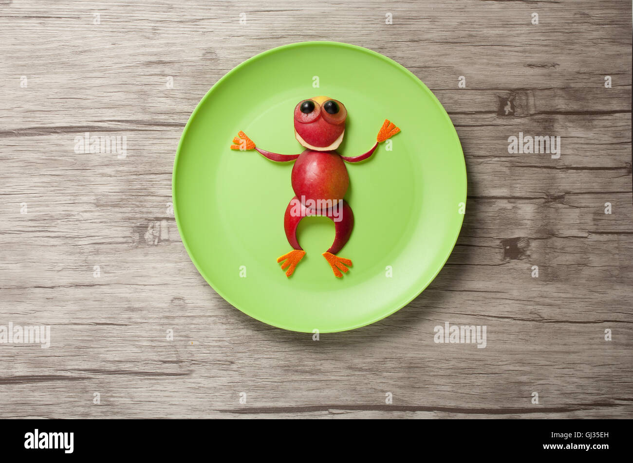 Funny Frog made of apple on plate and wood Stock Photo