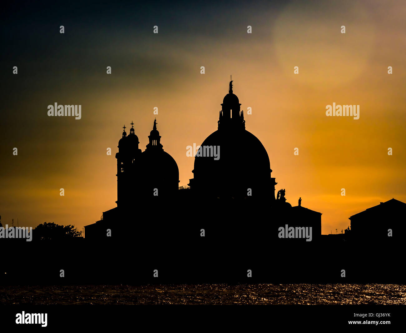 Silhouette of Santa Maria della Salute, Grand Canal, against a golden sky at sunset. Venice, Italy. Stock Photo