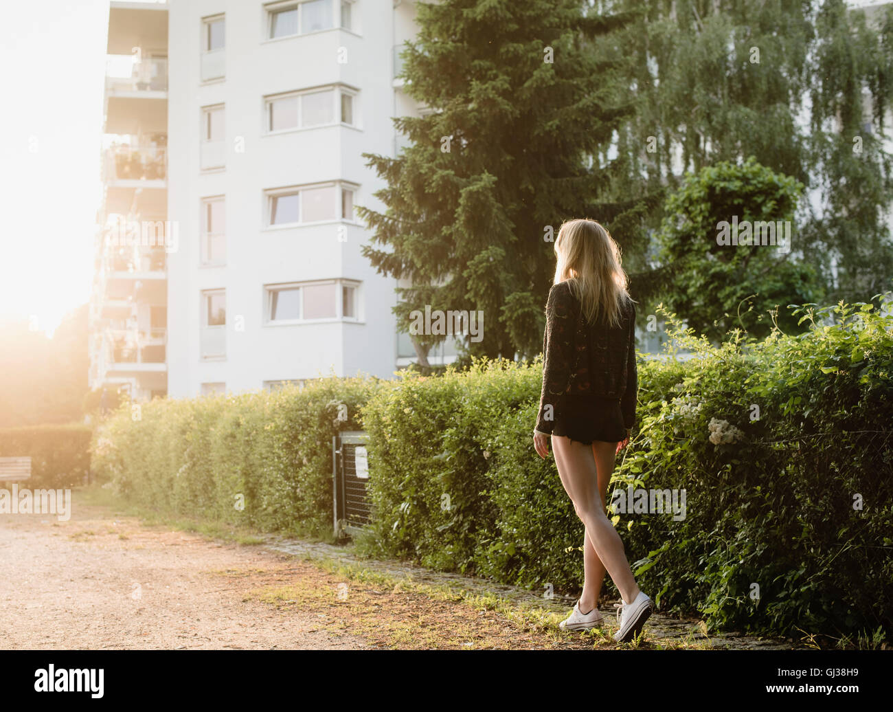 Young woman outdoors, walking along street, rear view Stock Photo - Alamy