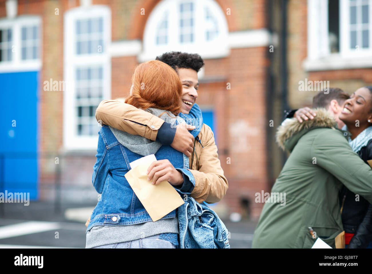 Young adult college students congratulating each others exam results on campus Stock Photo