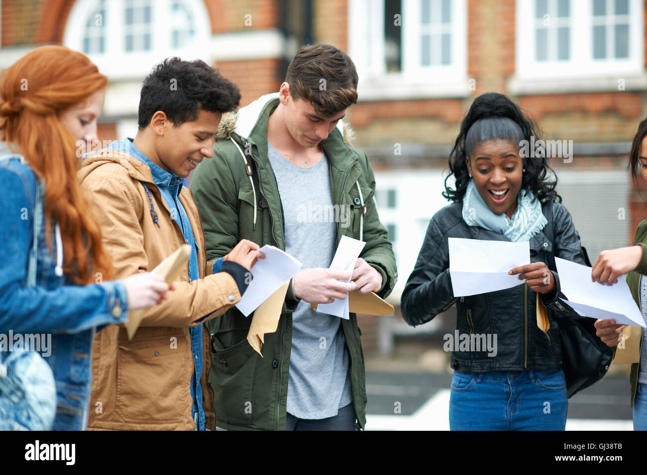 Young adult college students reading exam results on campus Stock Photo