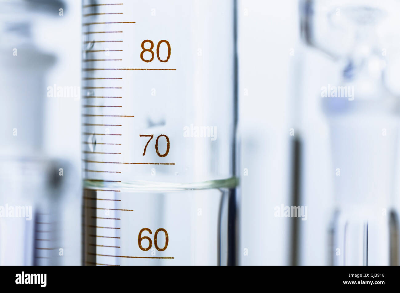 Chemical glassware. Graduated cylinder and other out-of-focus chemical lab glassware Stock Photo