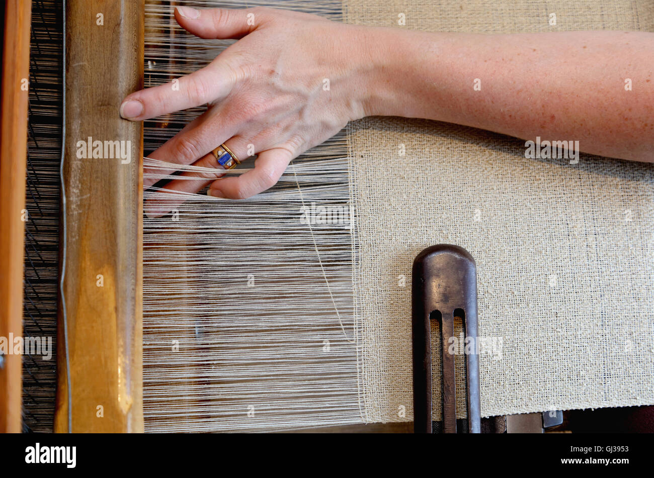 Hands of young woman using loom Stock Photo