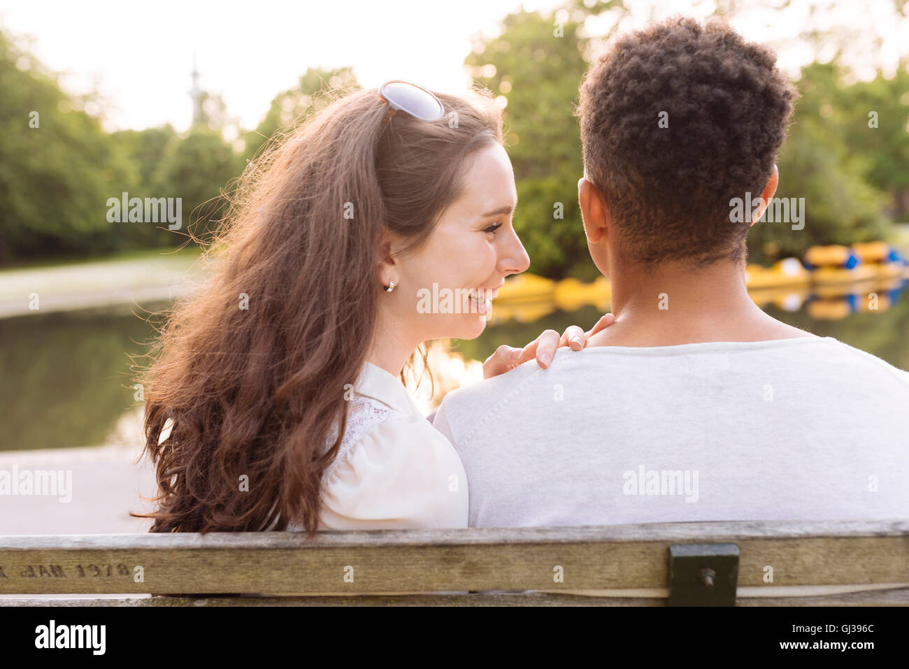 Rear view of young couple on park bench Stock Photo - Alamy