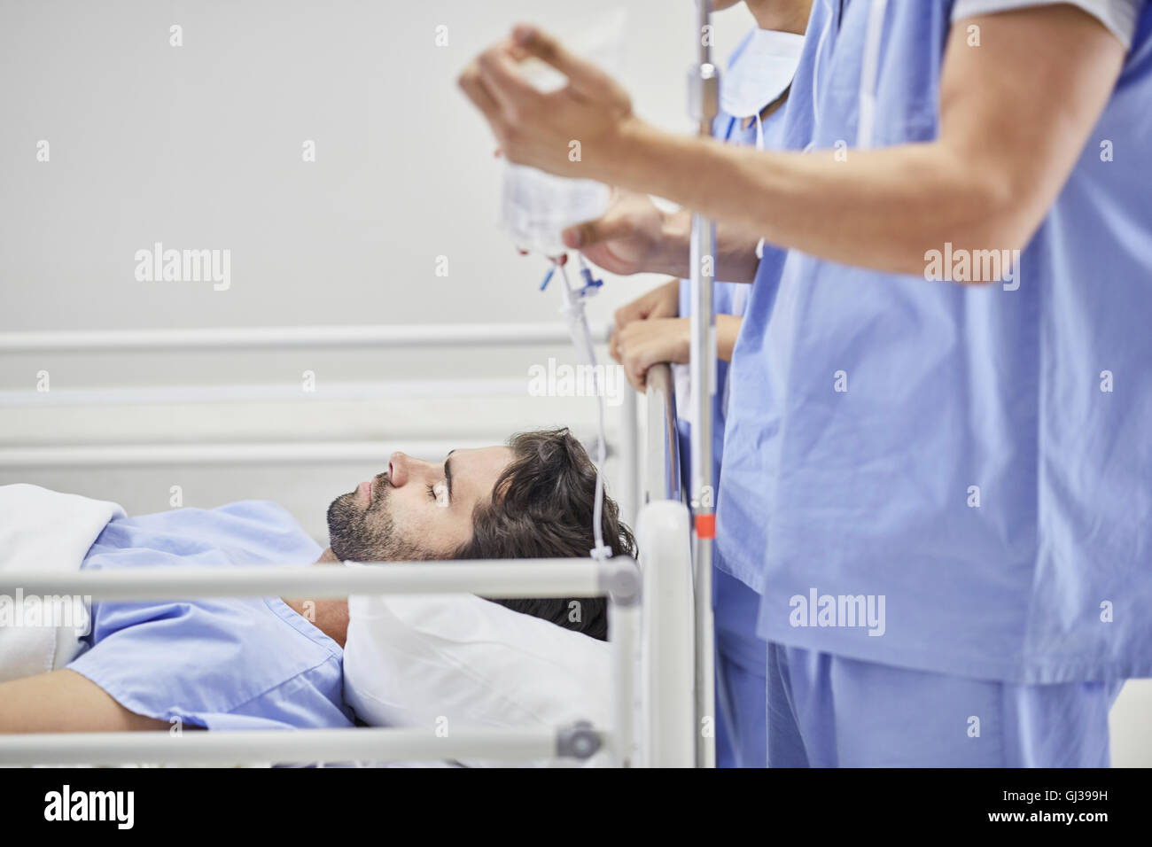 Doctor providing medical treatment to patient on hospital bed Stock Photo