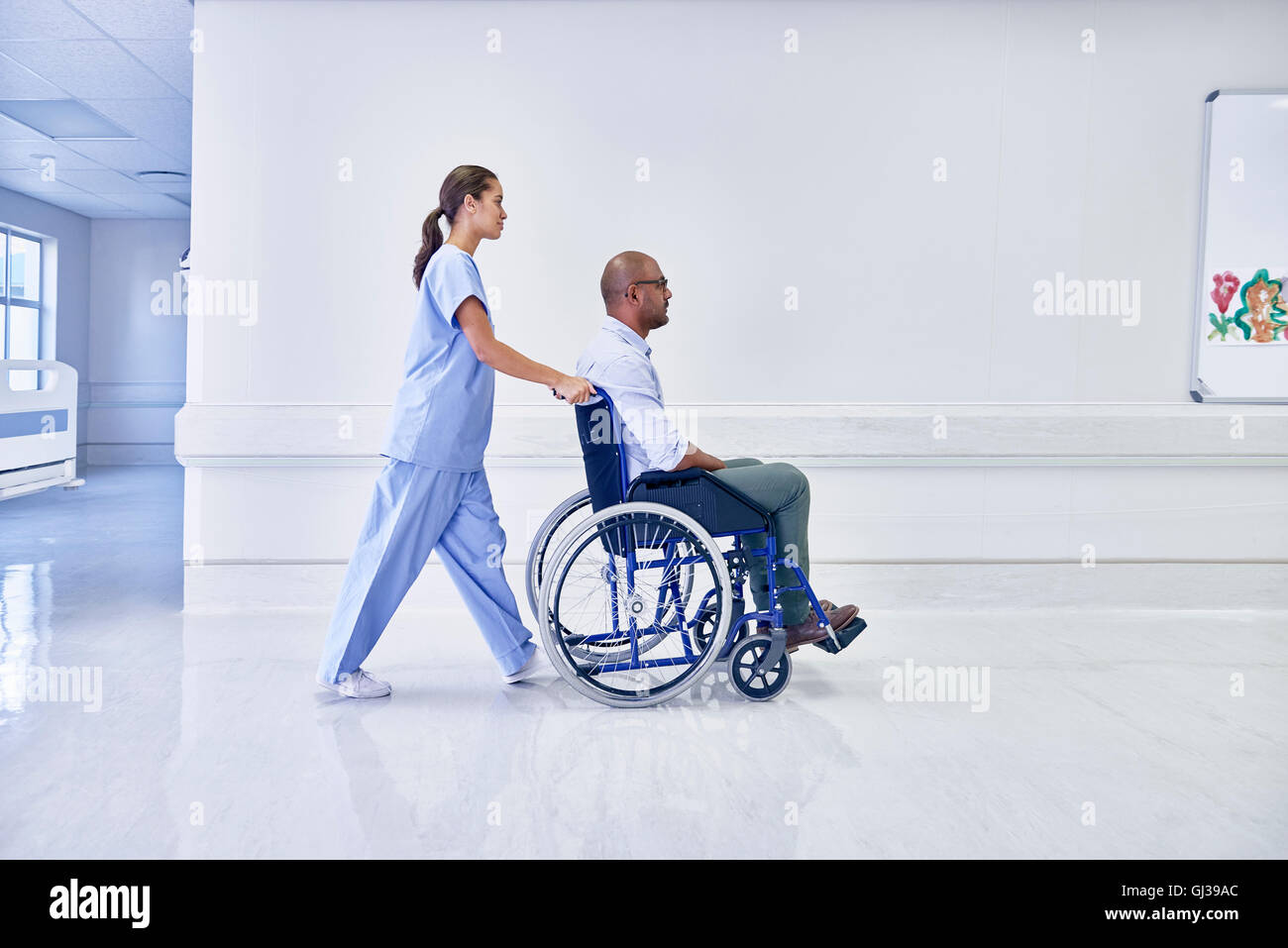 Doctor in hospital pushing patient in wheelchair Stock Photo