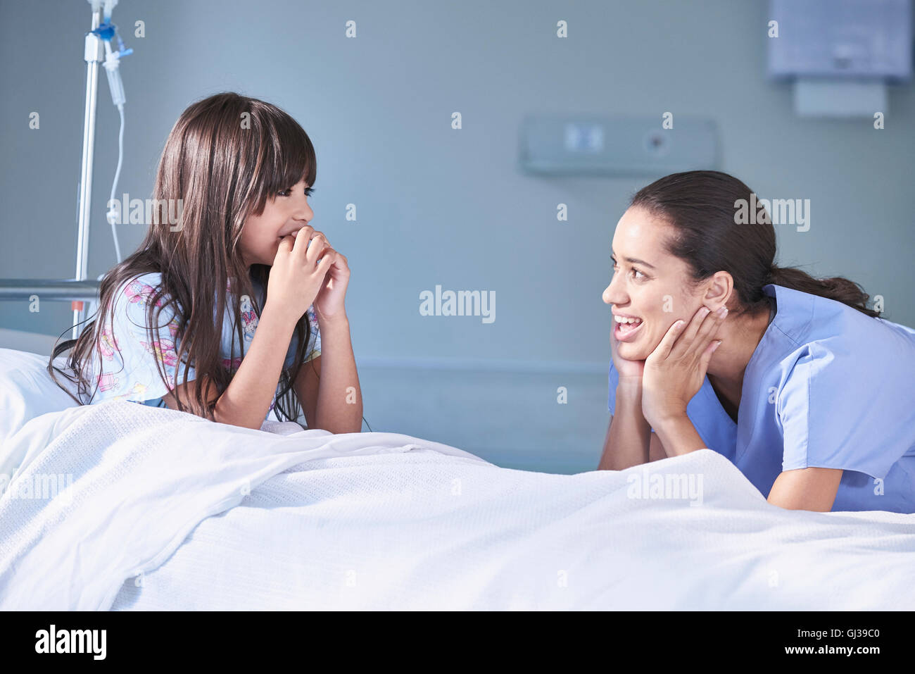 Girl patient talking to female nurse in hospital children's ward Stock ...