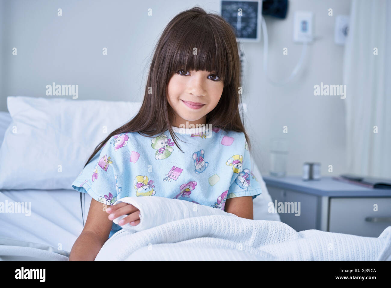 Portrait of girl patient with arm plaster cast in hospital children's ward Stock Photo