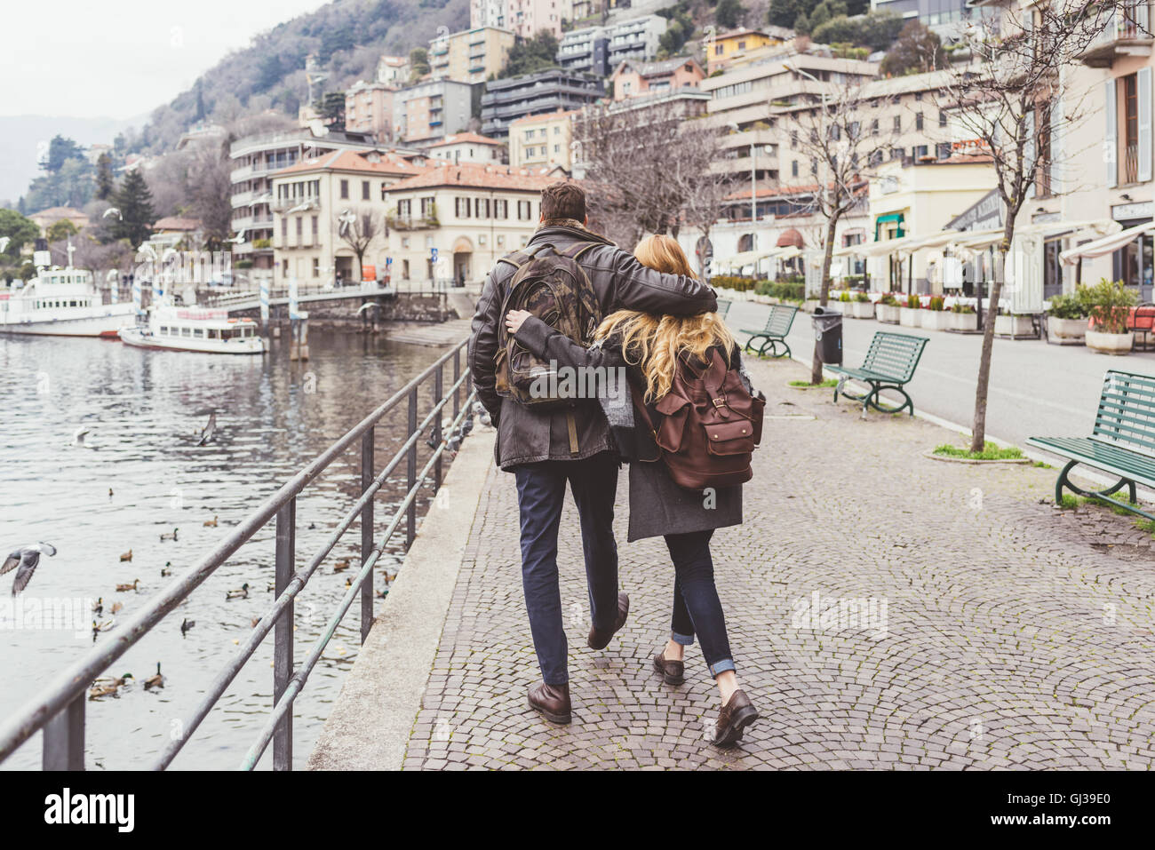 Rear view of young couple strolling along lakeside, Lake Como, Italy Stock Photo