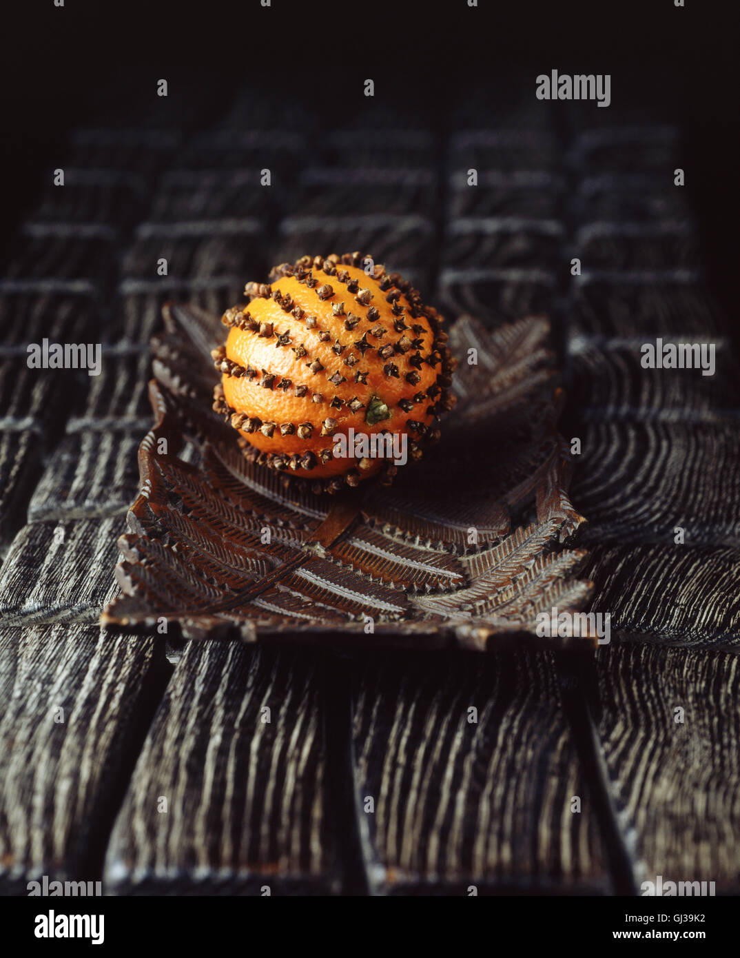 Orange with cloves stuck in, on vintage wooden plate Stock Photo Alamy