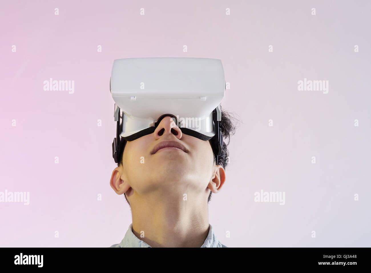Young man wearing virtual reality headset looking up Stock Photo