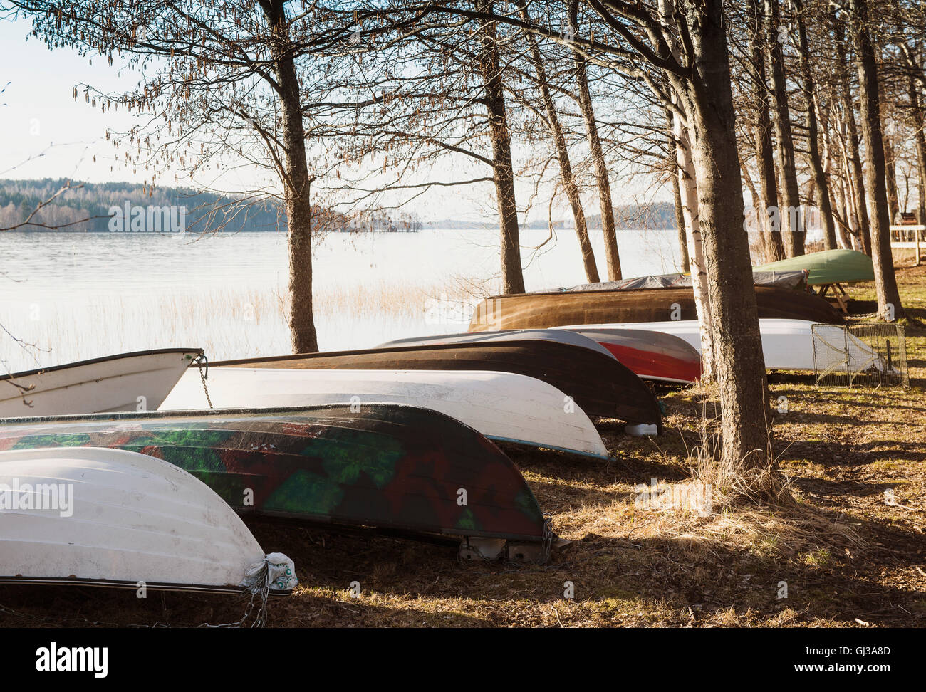 Row of upturned rowing boats on lakeside, Lahti, Finland Stock Photo