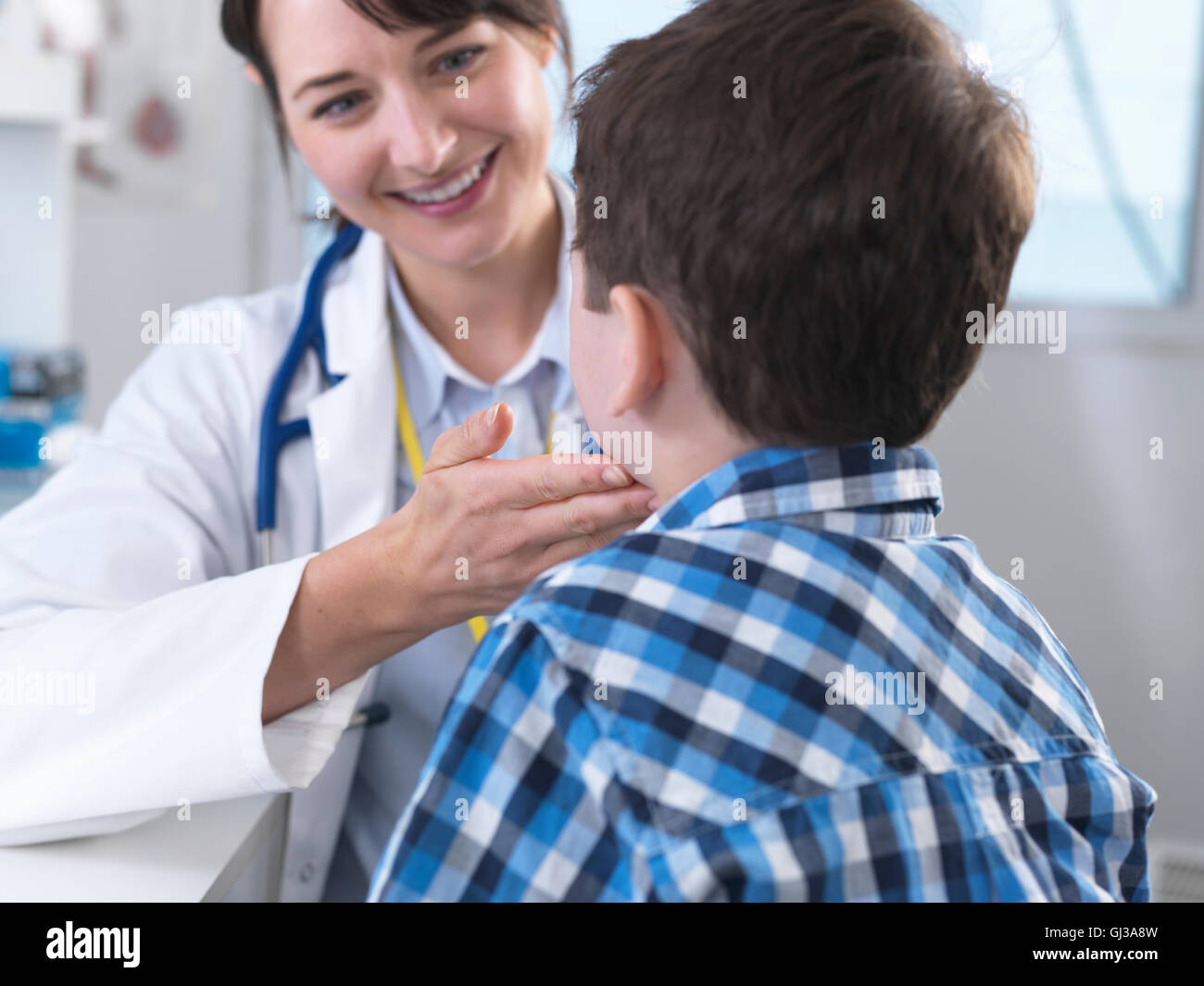 Doctor checking for swollen glands on boy's neck Stock Photo