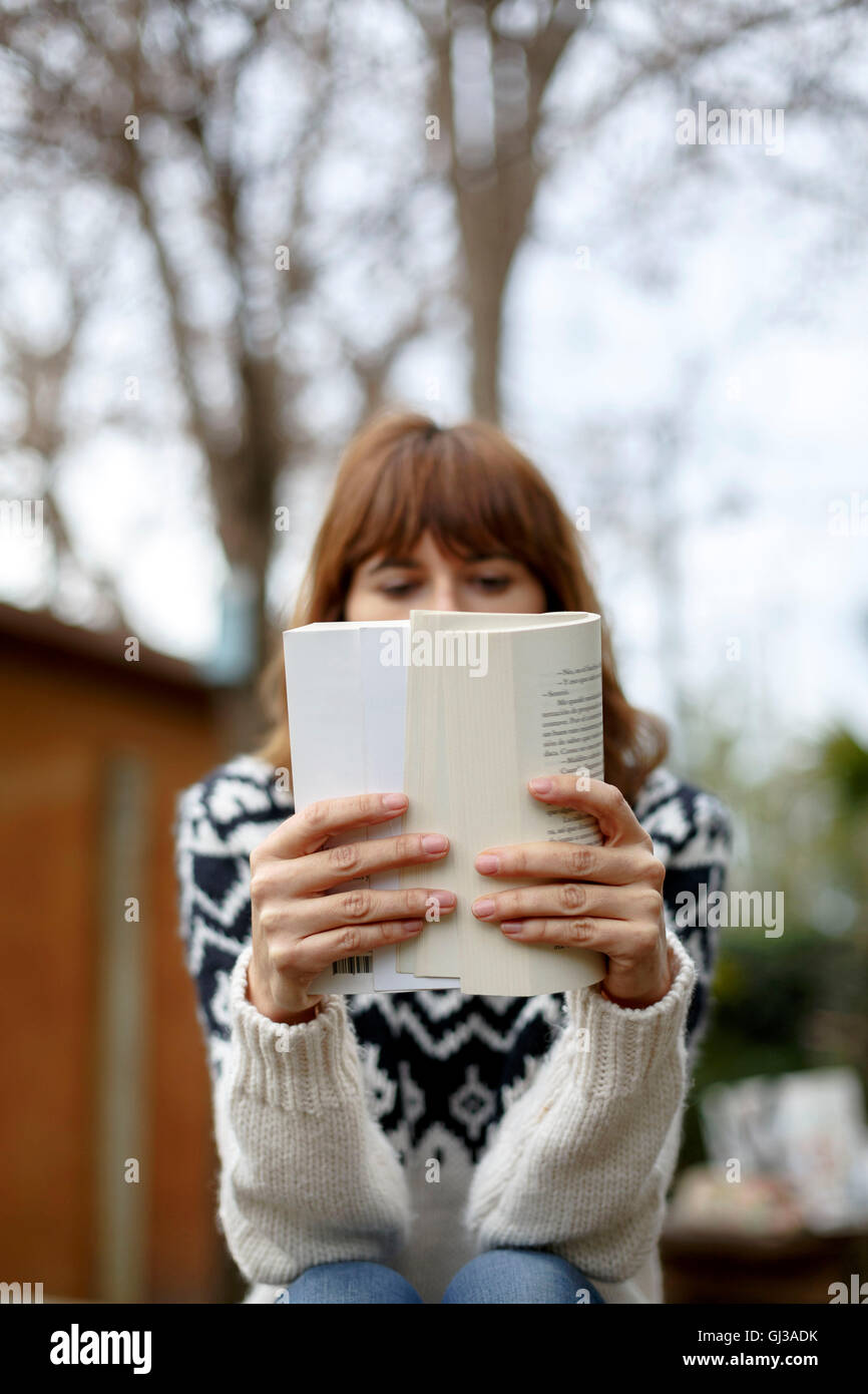 Woman reading book, face obscured Stock Photo