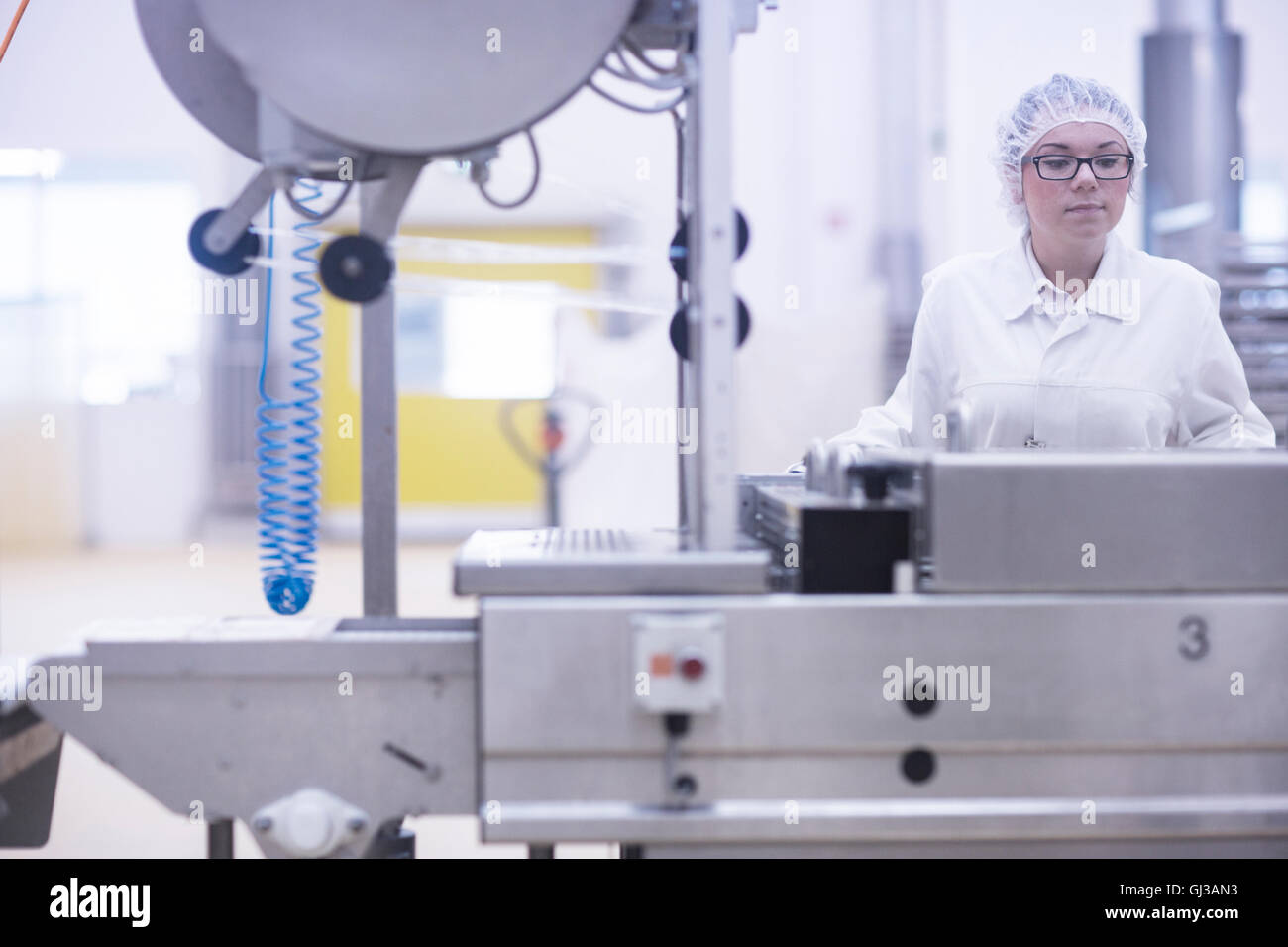 Factory worker operating food production machinery Stock Photo