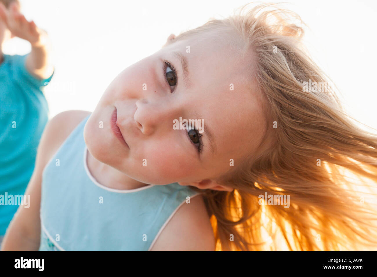 Portrait of girl, head cocked, looking at camera smiling Stock Photo