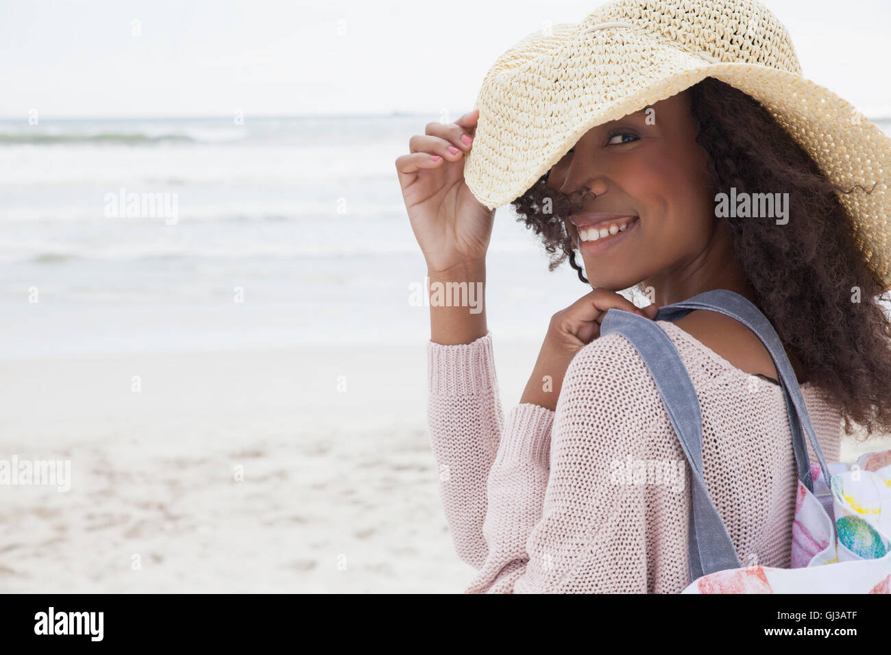 Young woman wearing hat on beach Stock Photo