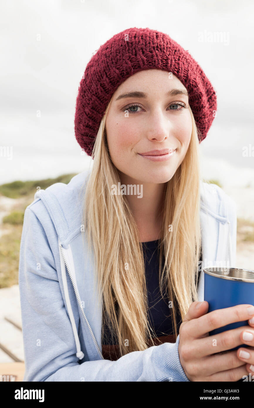 Young woman holding cup of coffee on cold day Stock Photo