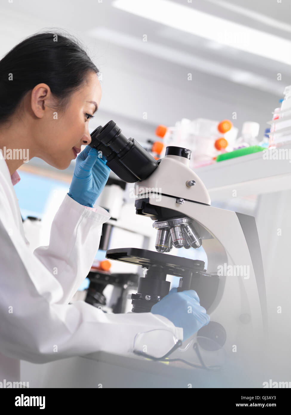 Scientist viewing a glass slide containing a human sample for medical testing Stock Photo