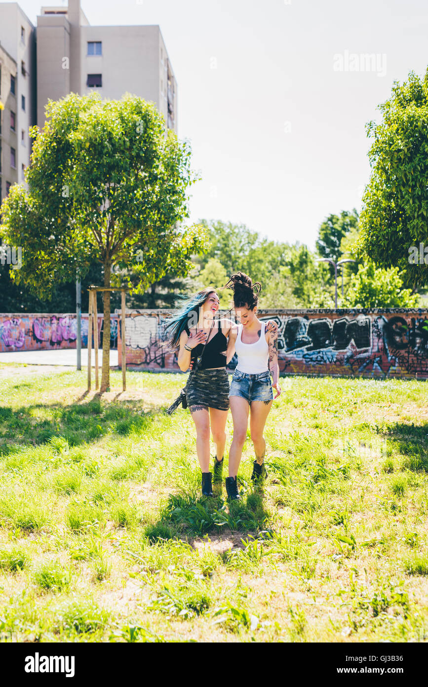 Two young women strolling in urban park Stock Photo - Alamy