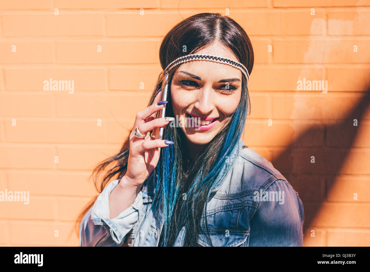 Young Woman With Dip Dyed Blue Hair Talking On Smartphone In Front