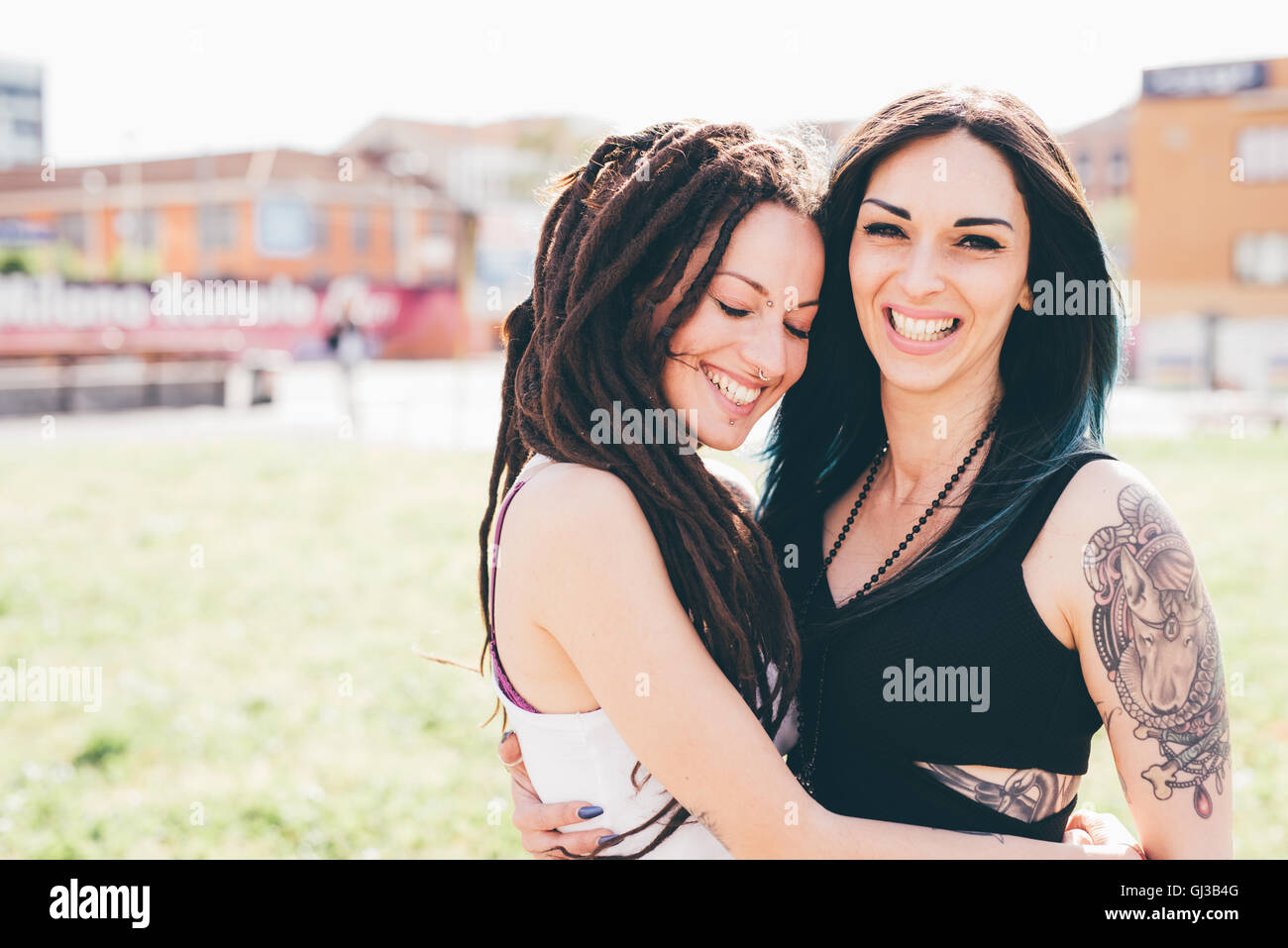 Portrait of tattooed young women in urban park Stock Photo