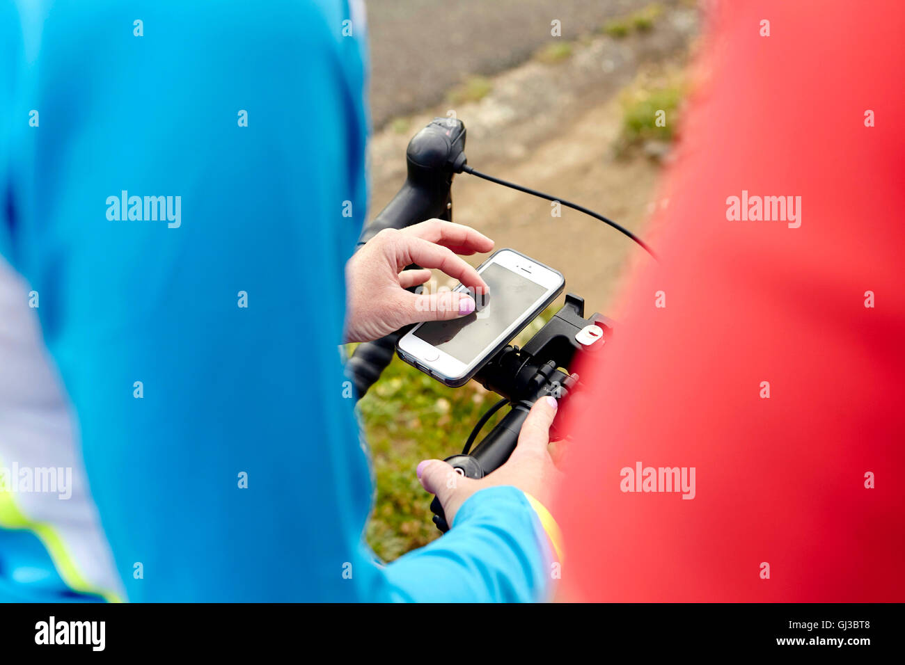 Cyclists stopping to use GPS on mobile phone Stock Photo