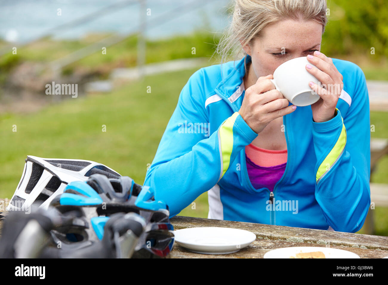Cyclist having breakfast at picnic table Stock Photo