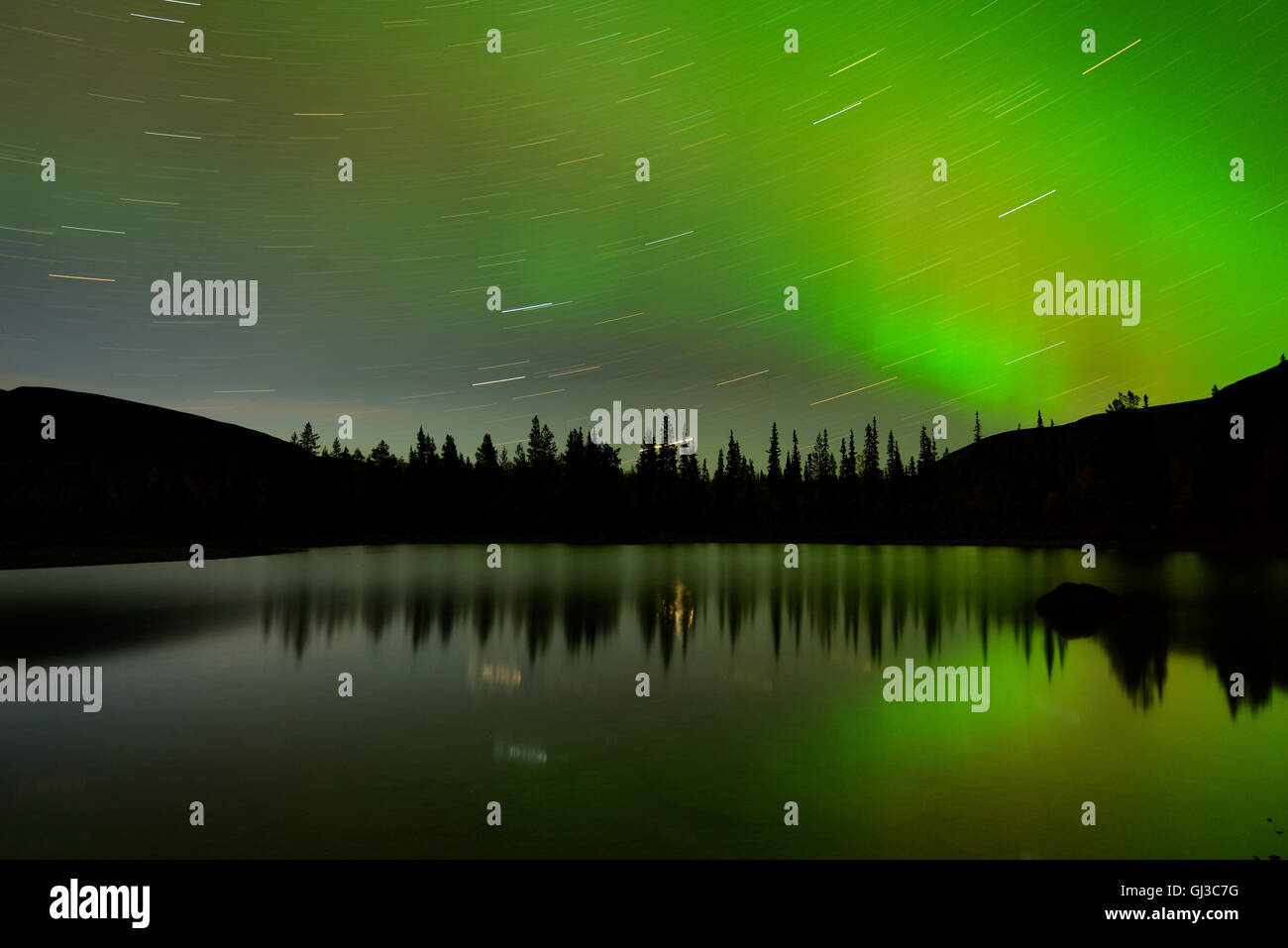 Swirling stars and aurora borealis at Polygonal Lakes at night, Khibiny mountains, Kola Peninsula, Russia Stock Photo