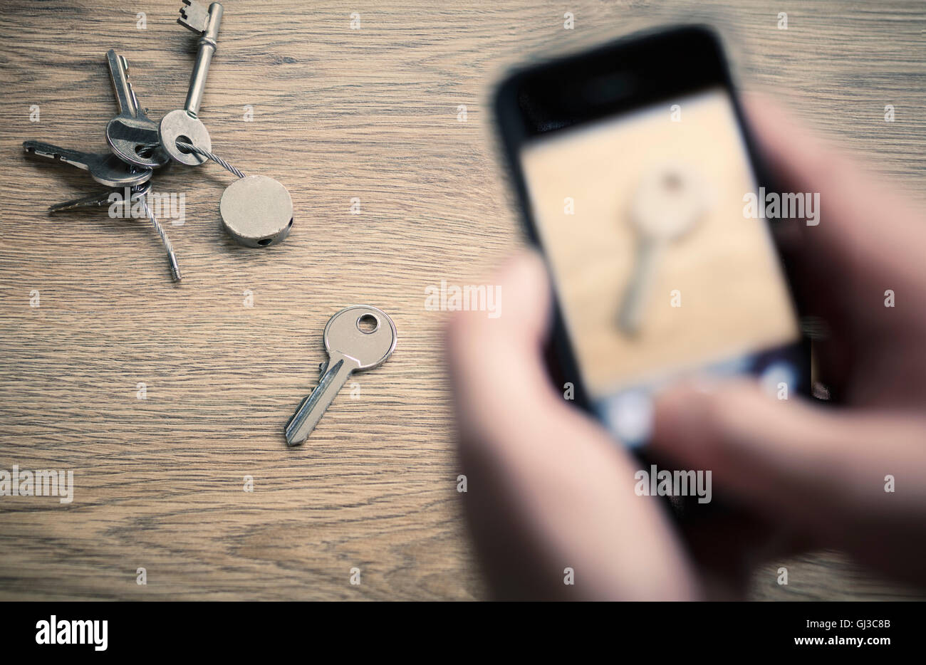 Man's hands taking photograph with smartphone of bunch of keys Stock Photo