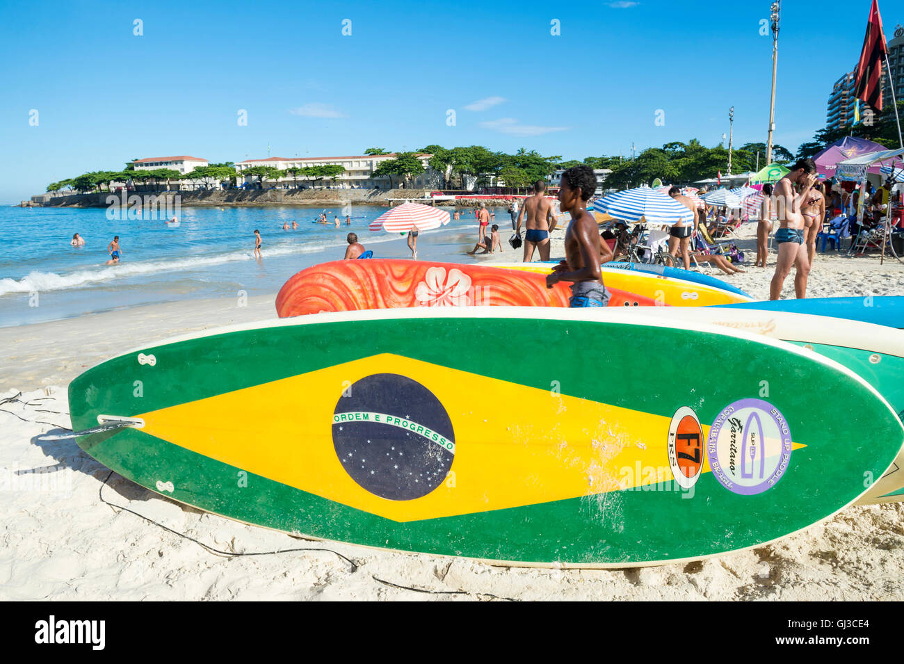 RIO DE JANEIRO - APRIL 5, 2016: Brazil flag stand up paddle surfboard waits for customers on Copacabana Beach. Stock Photo