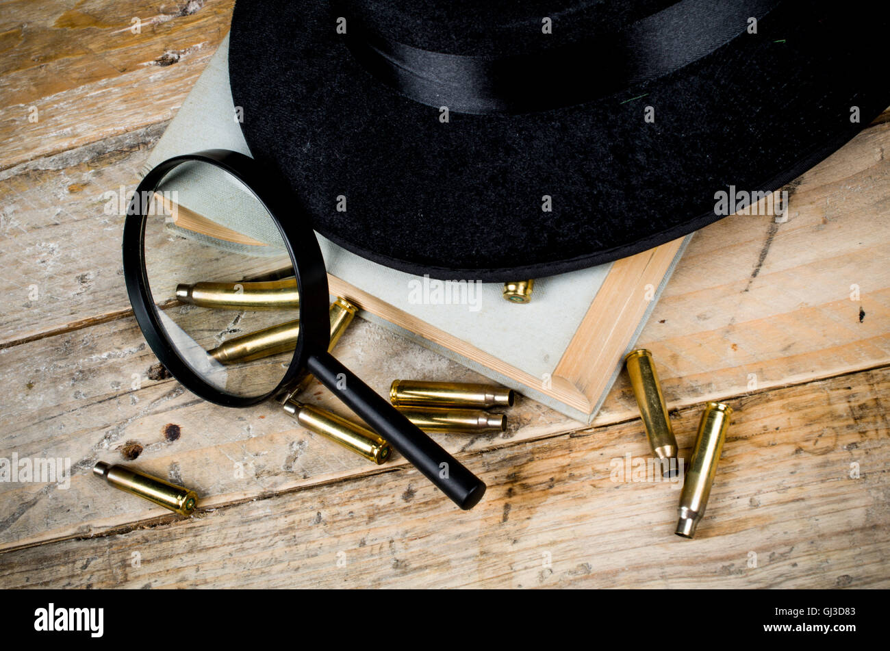 Fedora hat, bullets and magnifying glass, a film noir concept Stock Photo