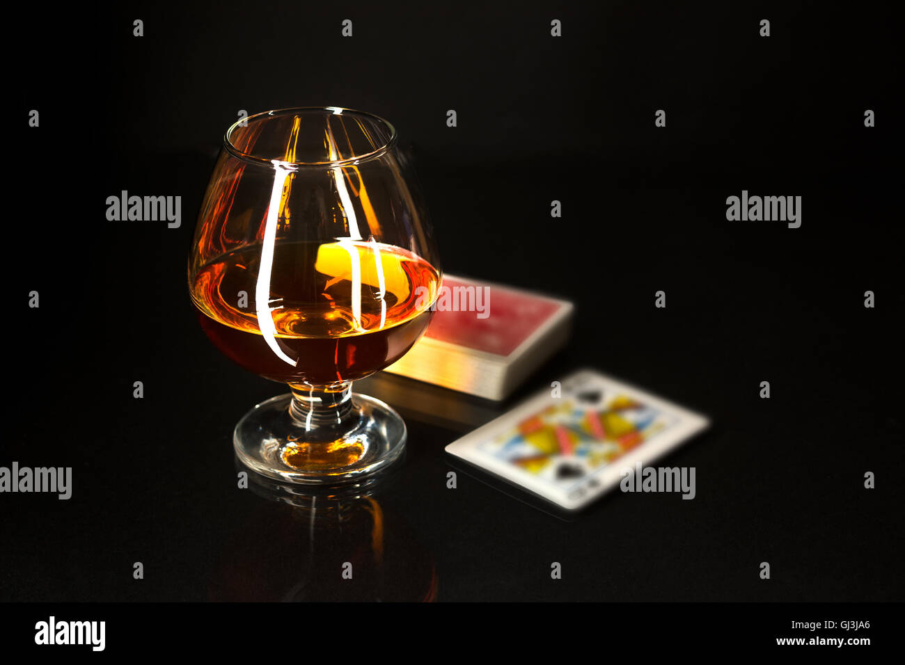 Whiskey glass and playing cards. Cognac glass. Brandy glassful. Cognac