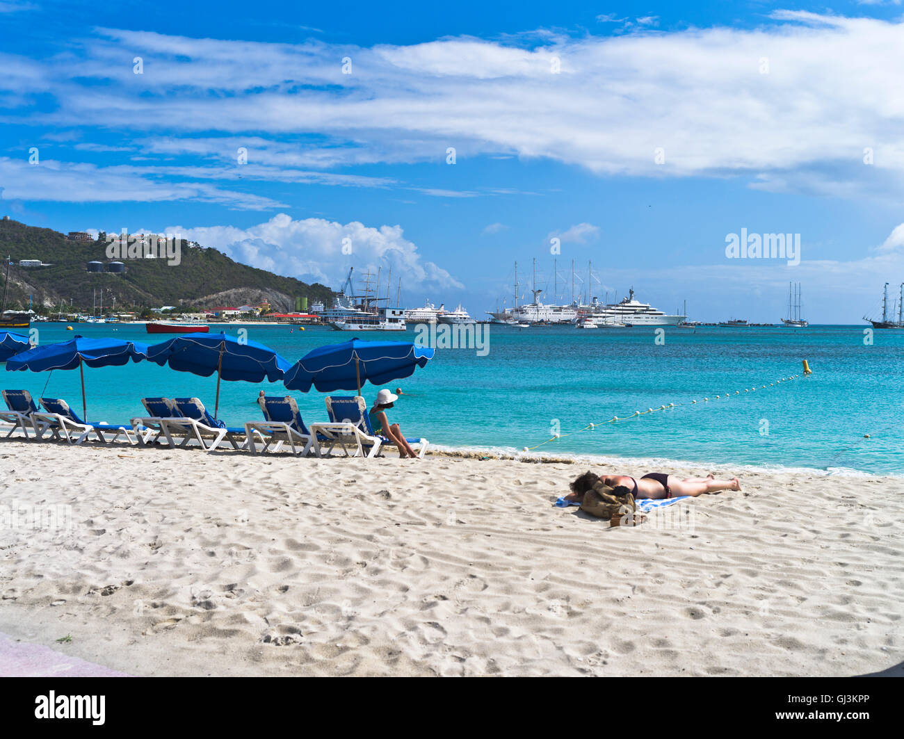 dh Philipsburg ST MAARTEN CARIBBEAN Sand beach sunbathers sun lounger umbrellas Cruise liners in port Stock Photo