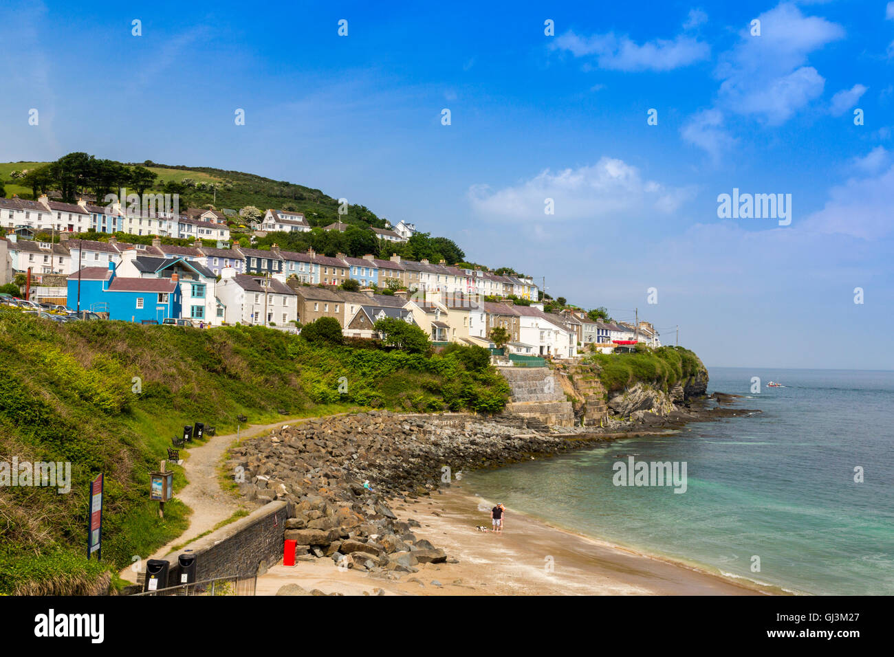 Rows of colourful terraced houses overlook a beach in New Quay