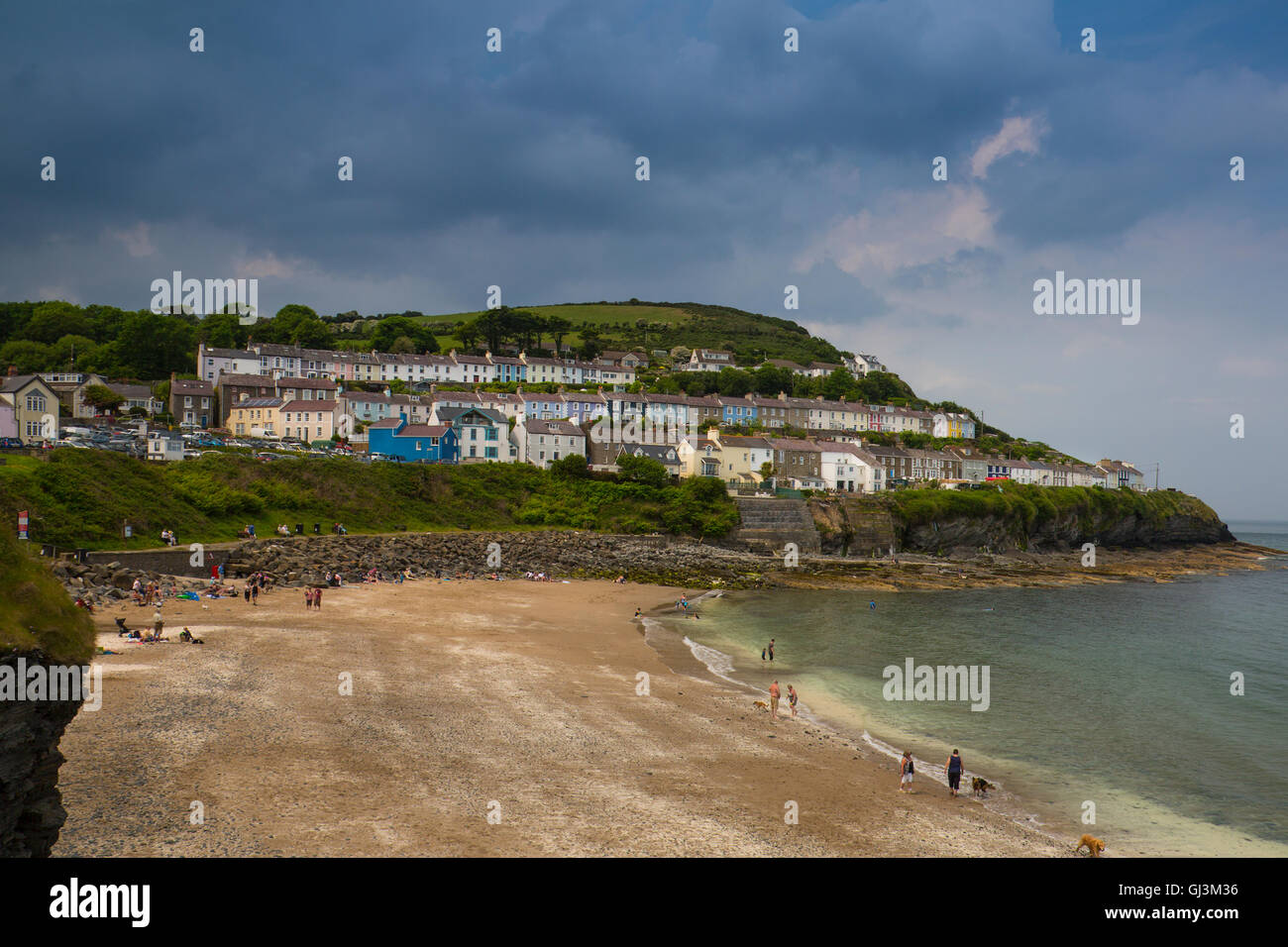 Rows of colourful terraced houses overlook a beach in New Quay