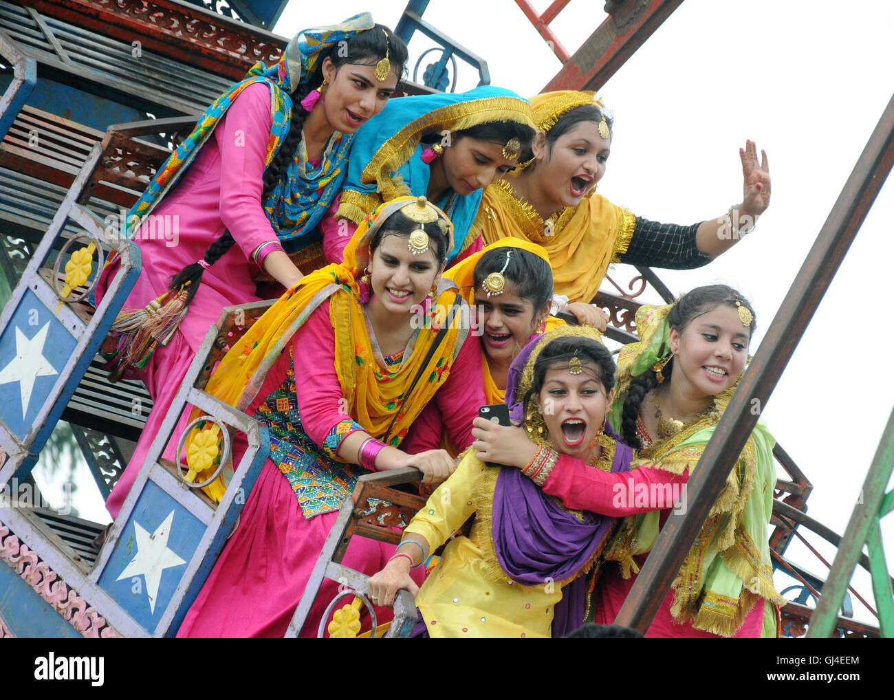 (160813) -- AMRITSAR (INDIA), Aug. 13, 2016 (Xinhua) -- College girls wearing traditional Punjabi dresses ride 'viking ship' during the celebration of Teej Festival in Amritsar, India, Aug. 13, 2016. Teej is a generic name for a number of festivals celebrated among females to welcome monsoon season in northern and western India and Nepal. (xinhua/stringer) (wtc) Stock Photo