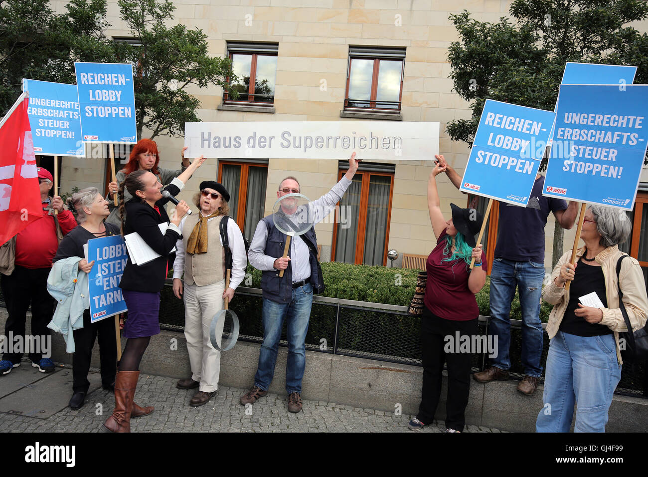 Berlin, Germany. 11th Aug, 2016. People participating in a protest against loop holes for rich people in the inheritance tax organised by the organisations Verdi, attac, Campact and others in front of 'Haus des Familienunternehmens' (lit. 'House of the Family Business') in Berlin, Germany, 11 August 2016. PHOTO: WOLFGANG KUMM/dpa/Alamy Live News Stock Photo