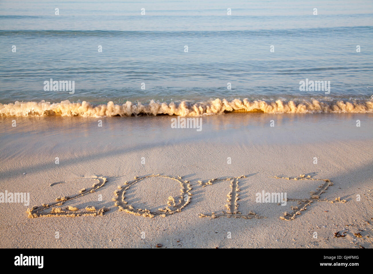 Year and number 2017 written on the sand on a beach Stock Photo