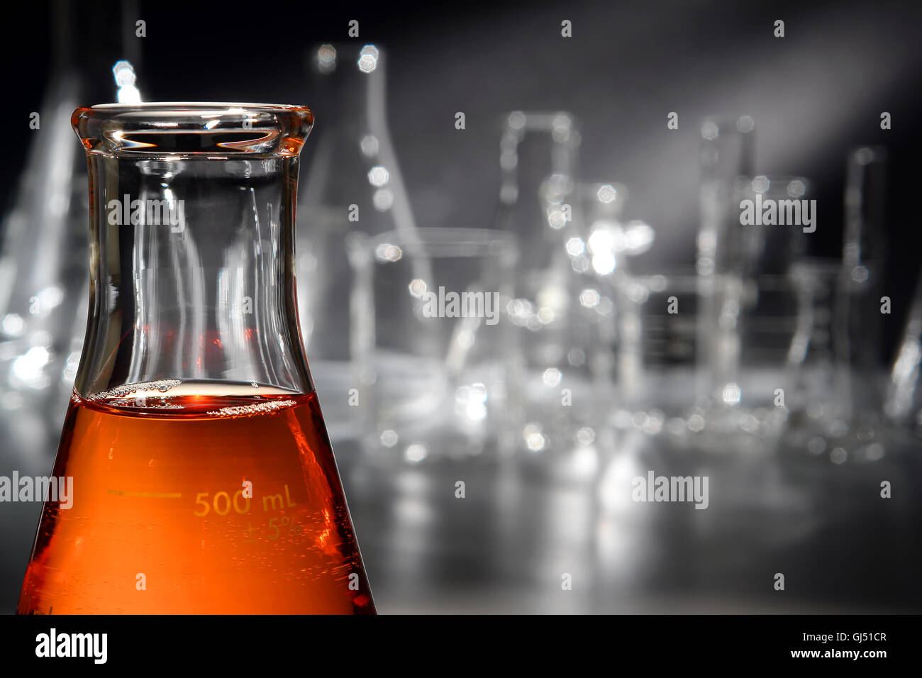 Scientific laboratory glass conical Erlenmeyer flask filled with amber ...