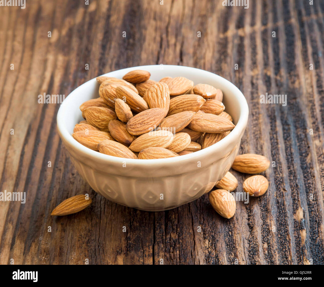 fresh almonds in a bowl on wooden background,healthy nuts Stock Photo