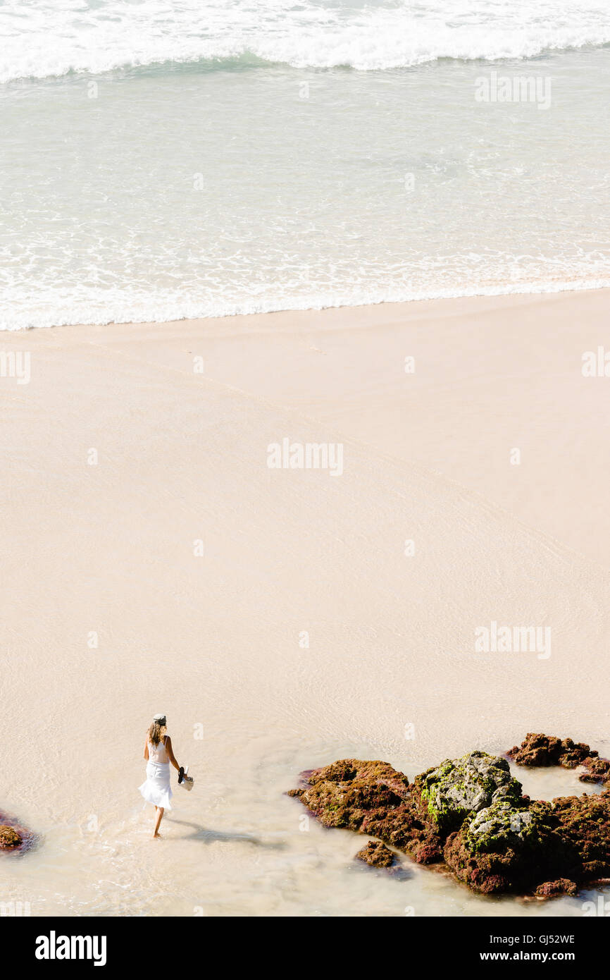 A woman walking along Wategos Beach in Byron Bay. Stock Photo