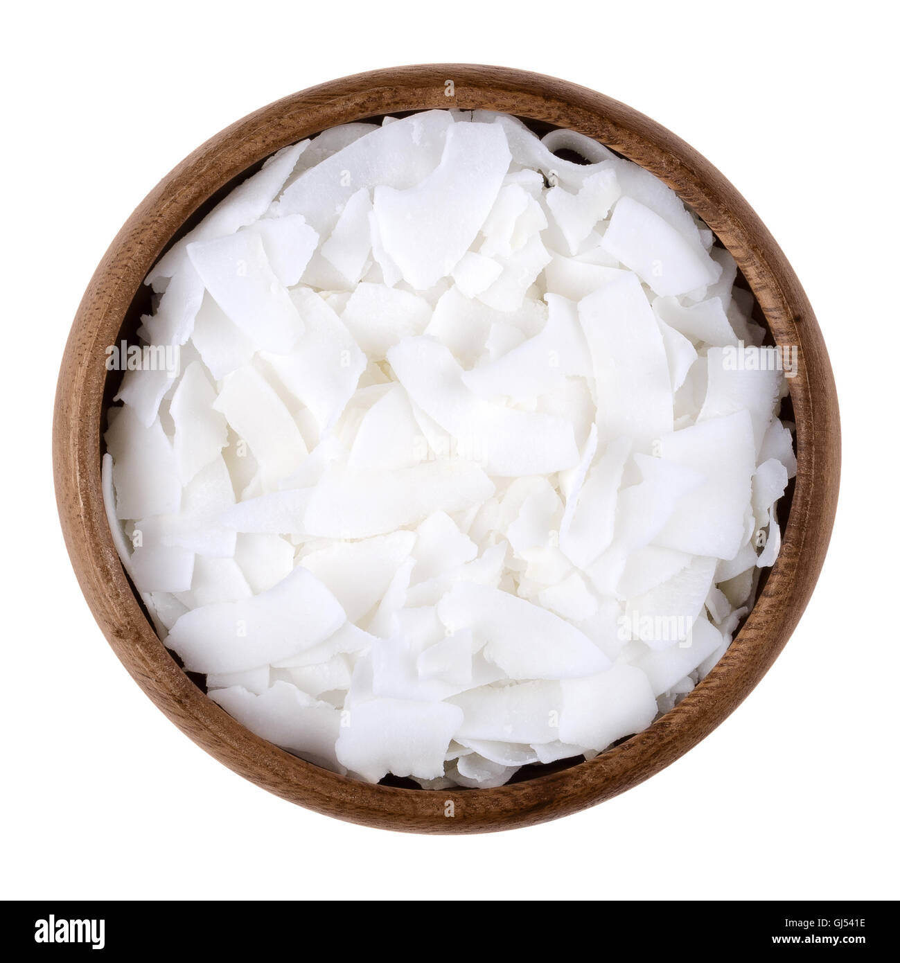Coconut flakes in a bowl on white background, also called copra. Dried and grated flesh or meat of the coconut kernel. Stock Photo