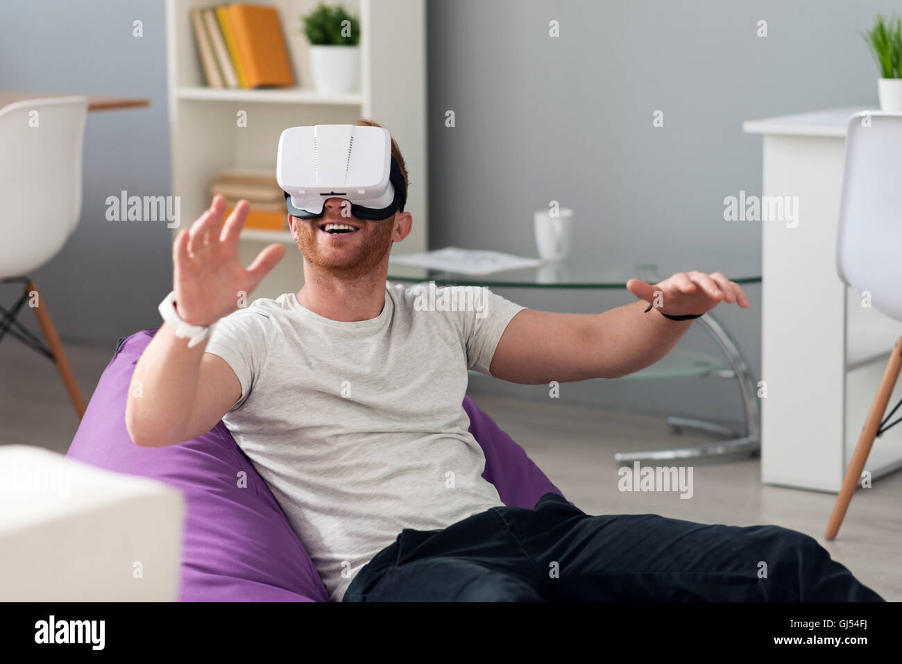 Man Using The Virtual Reality Positive man using virtual reality device Stock Photo - Alamy