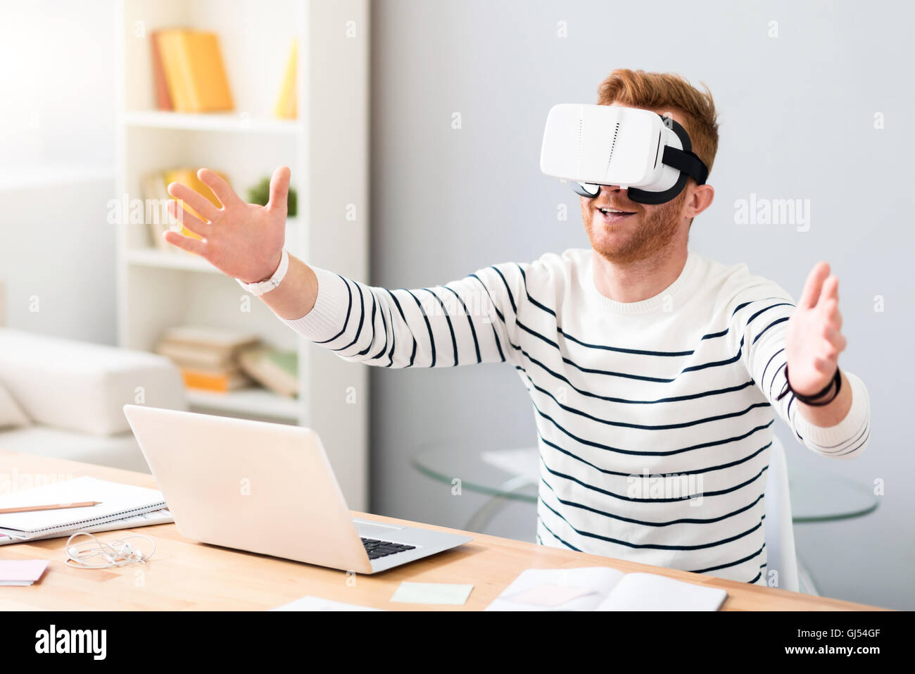 Man Using The Virtual Reality Cheerful man using virtual reality device Stock Photo - Alamy