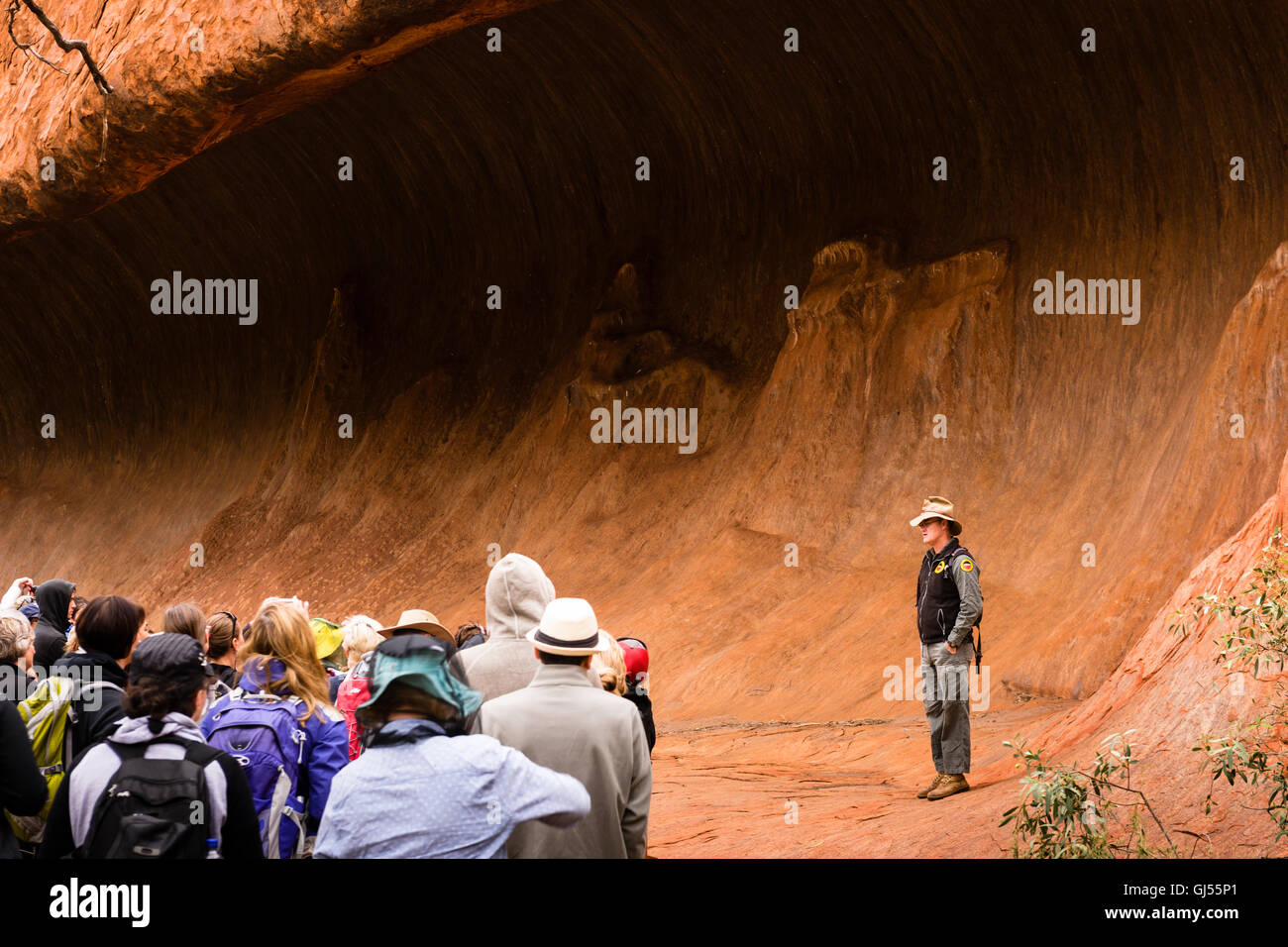 A ranger with a group of tourists on the Mala Walk at Uluru in the Uluru-Kata Tjuta National Park. Stock Photo